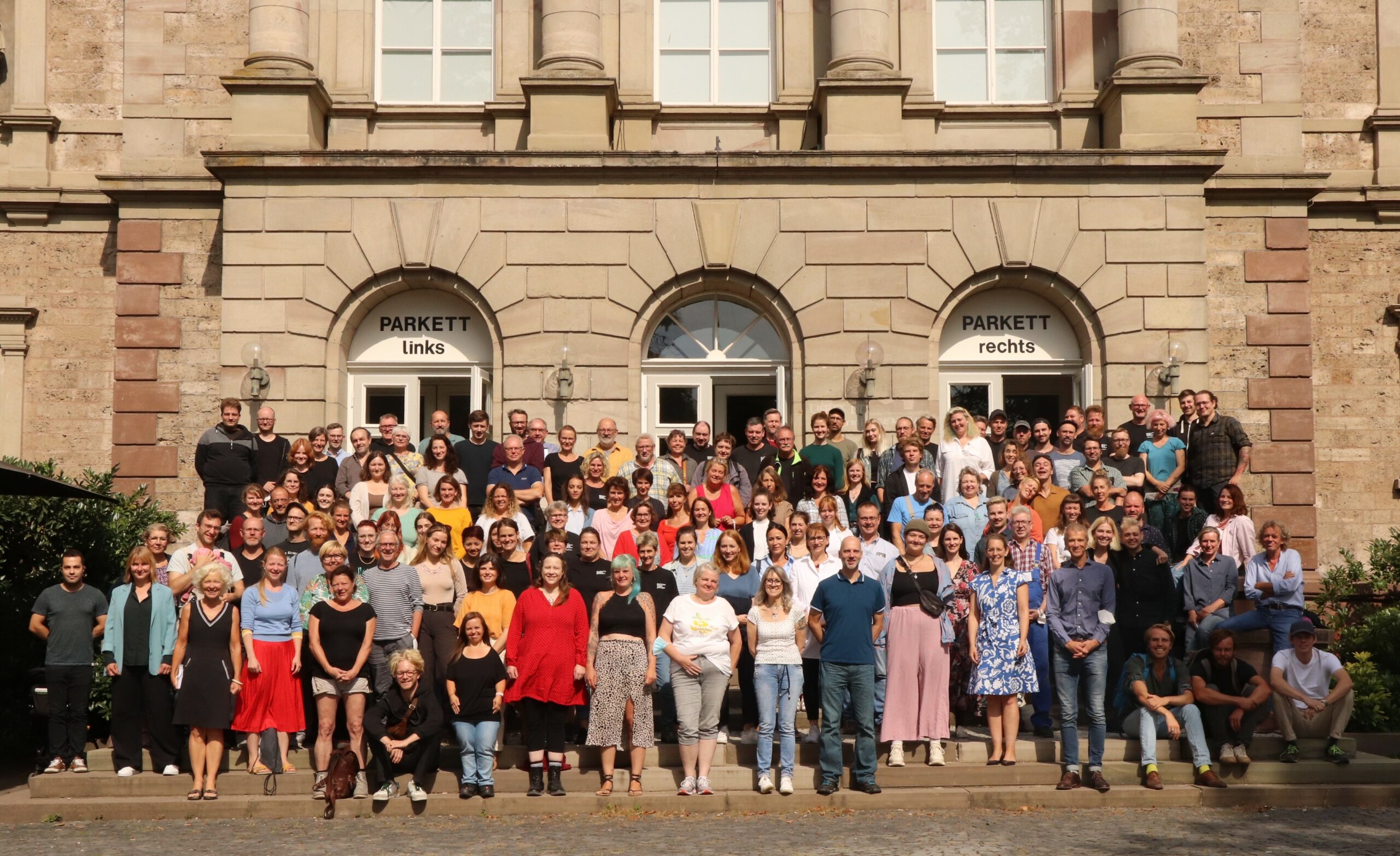 Mitarbeiter*innen auf der Treppe vor dem Theater